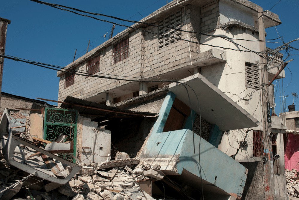 A building with rubble and wires in front of it.